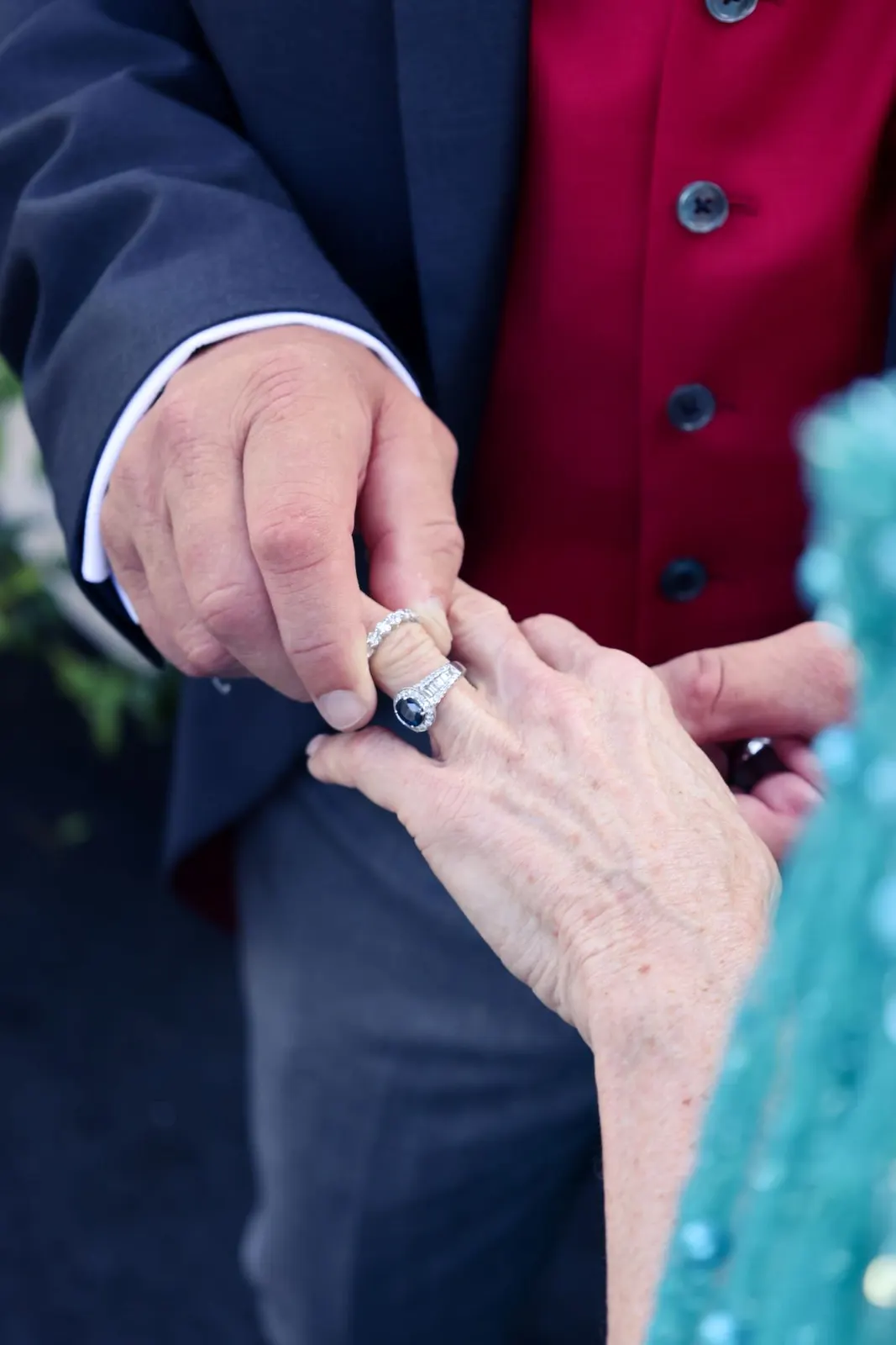 Groom slipping a ring onto the bride’s finger